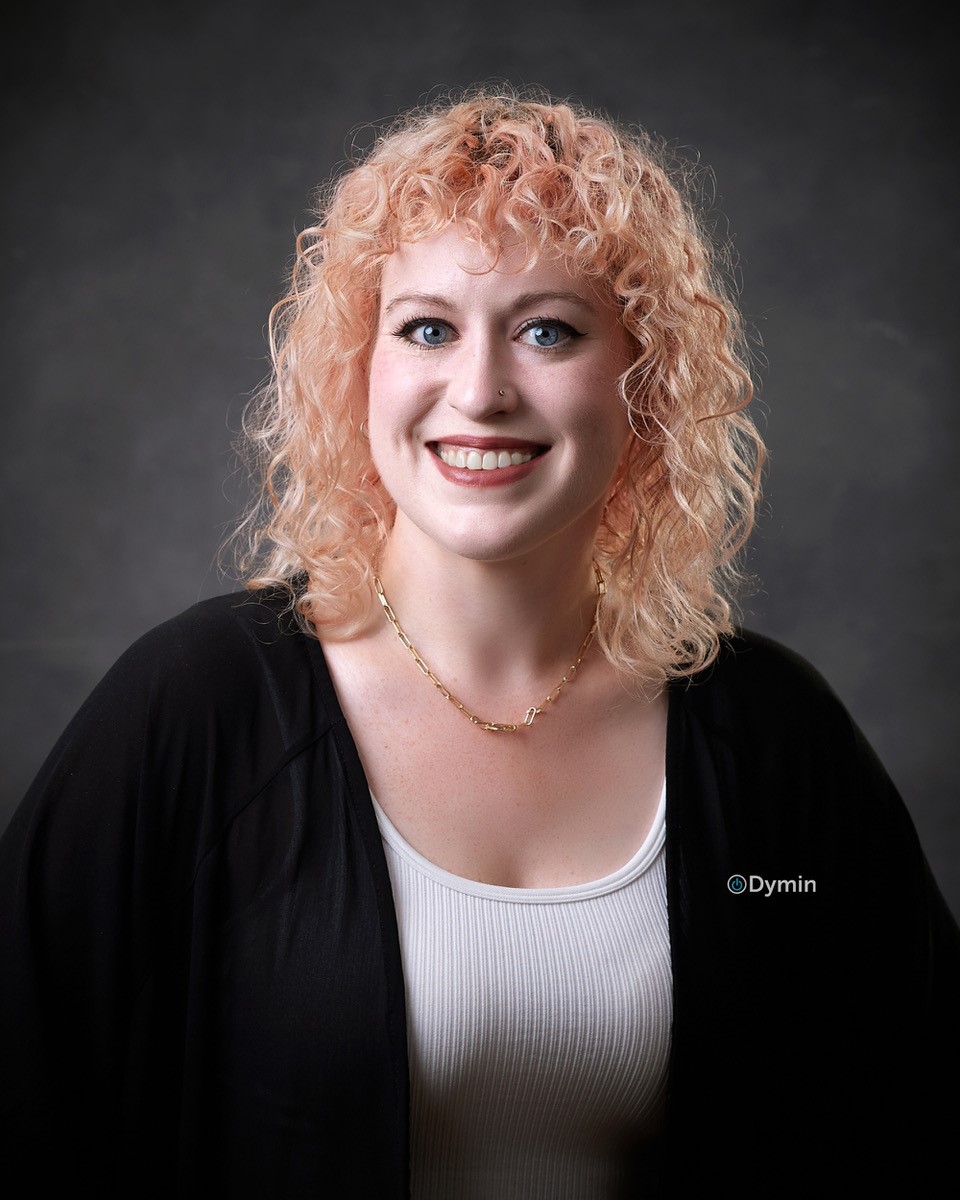 a woman with blonde hair smiling at the camera