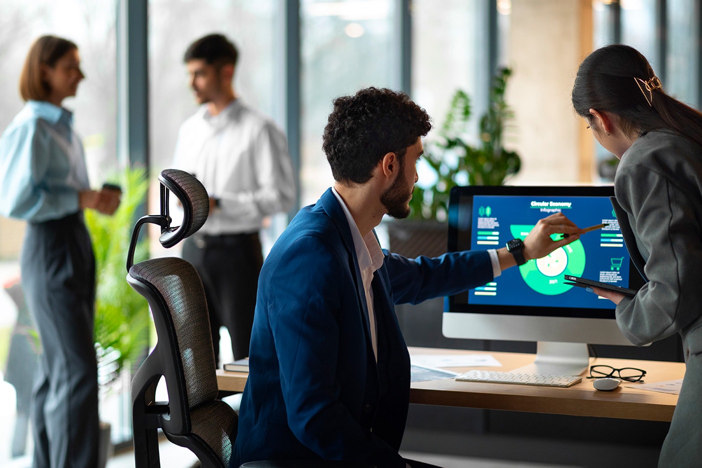 a group of people standing around a computer screen