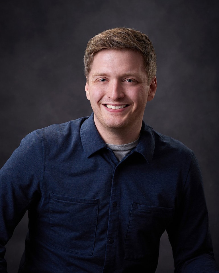 a man in a blue shirt is posing for a picture