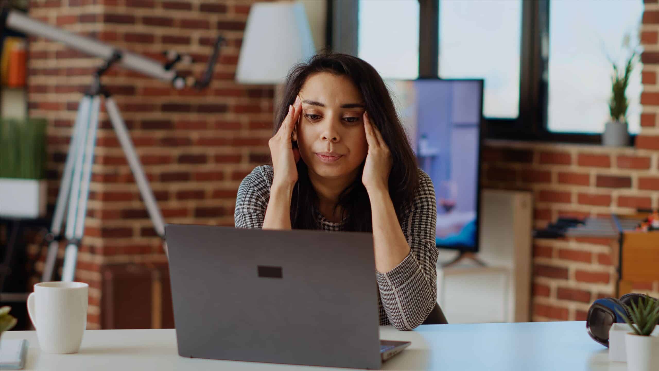 a woman sitting in front of a laptop computer